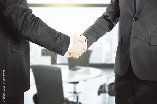 Handshake of two businessmen in a conference room