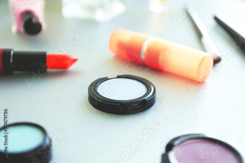 Red lipstick with eye shadows on a table