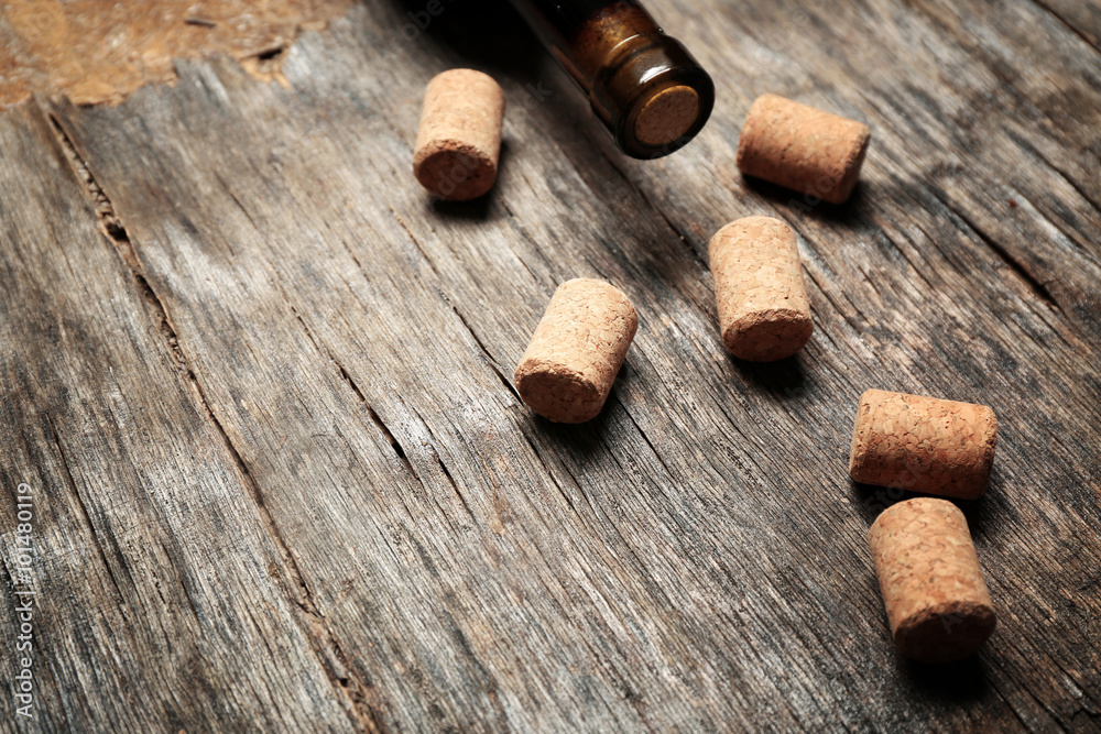 Wine corks and bottle on old wooden background