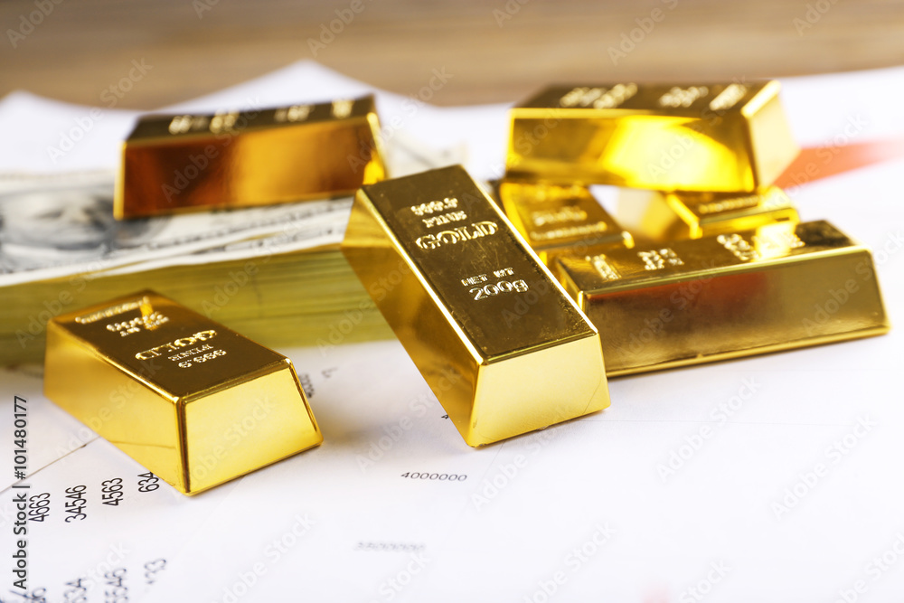 Gold bars with dollar banknotes on paper background, close up Gold bars with dollar banknotes on paper background, close up
