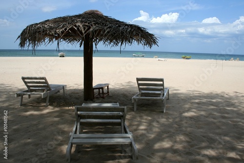 Fototapeta Naklejka Na Ścianę i Meble -  Relaxation on the white sand beach with white bed and parasol (umbrella)