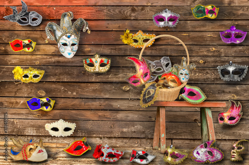 Carnival masks hanging on wall boards lie on floor and bench i