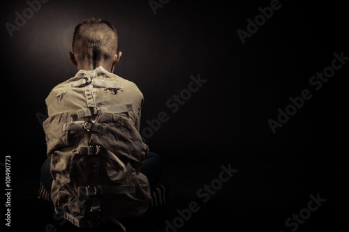 Lonely Poor Boy Facing Backward Against Black