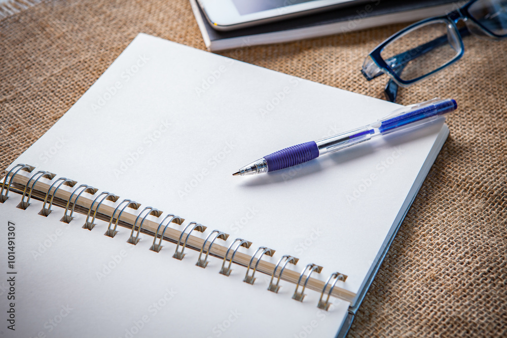 Fotografie still life of white paper note book page with writing pen lying