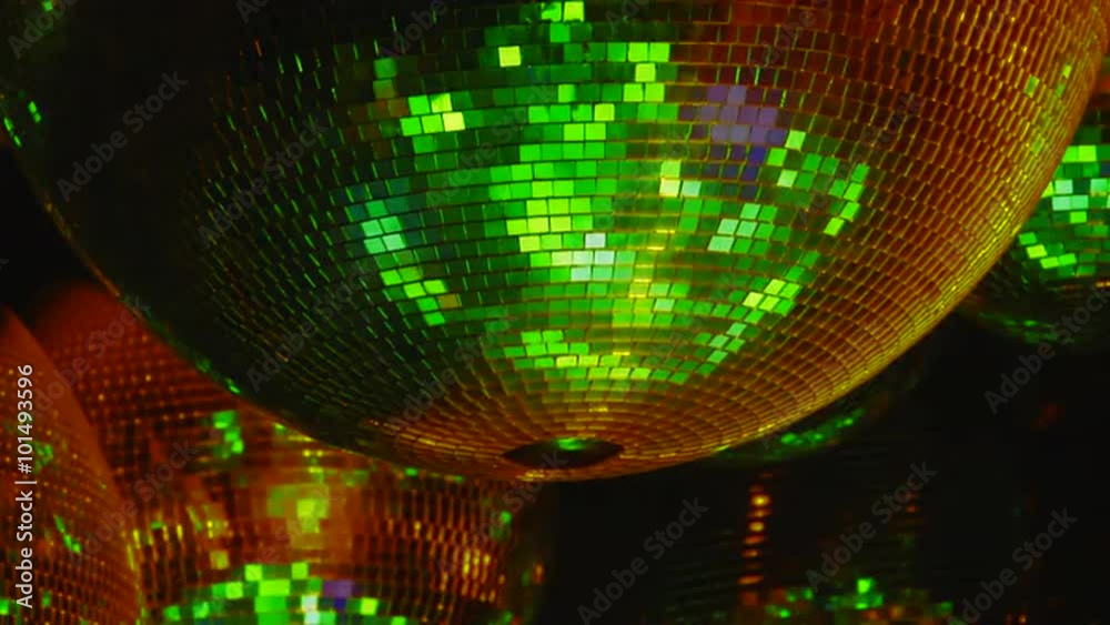 Mirror balls reflect rays of colored lights. Colorful reflective disco mirror ball with glinting