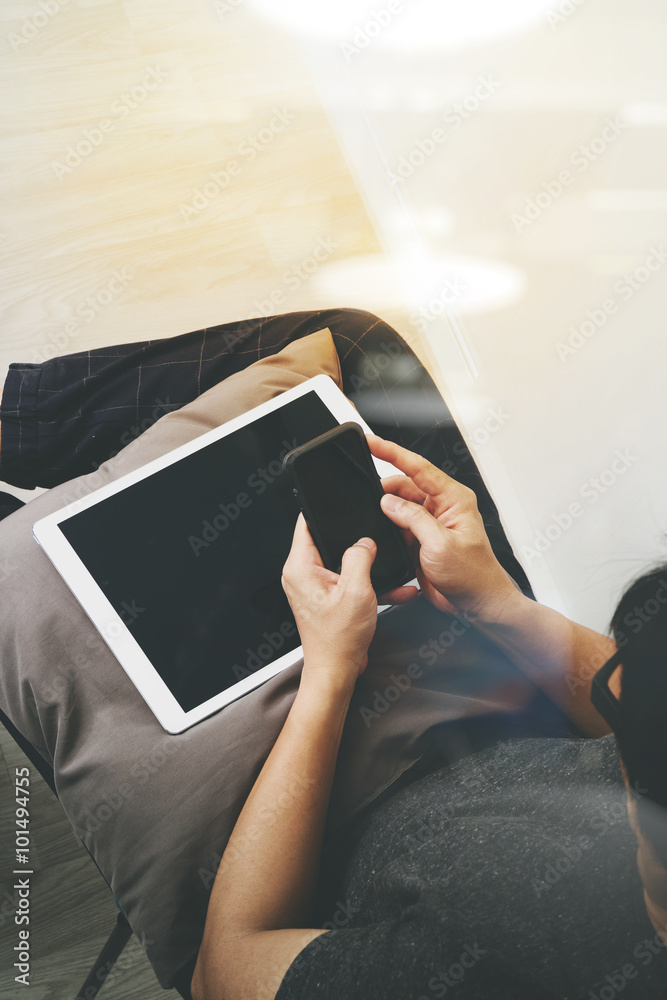 Obraz premium top view of hipster hands using smart phone and digital tablet p