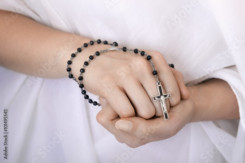 Young woman's hands with a rosary