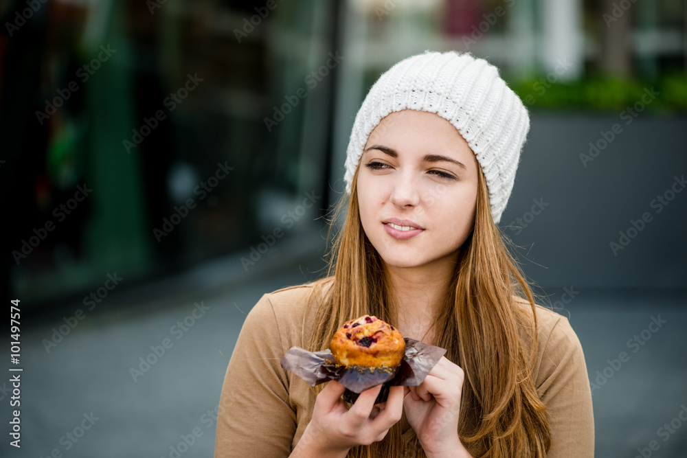 Teenager eating  muffin