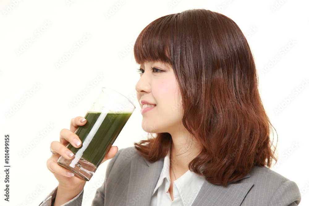 young Japanese businesswoman with green vegetable juice young Japanese businesswoman with green vegetable juice