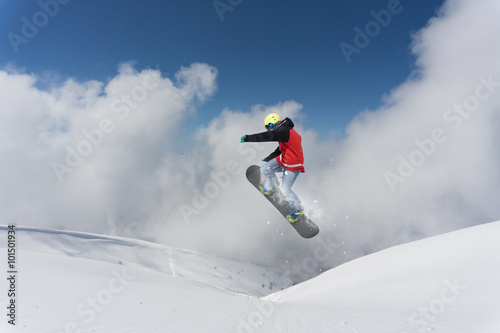 Flying snowboarder on mountains. Extreme sport.