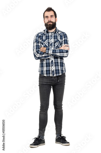 Confident bearded man with crossed arms in tartan plaid shirt looking at camera. Full body length portrait isolated over white studio background.