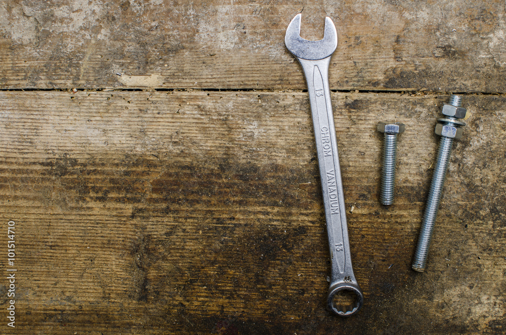 Wrench and screw on old wooden table