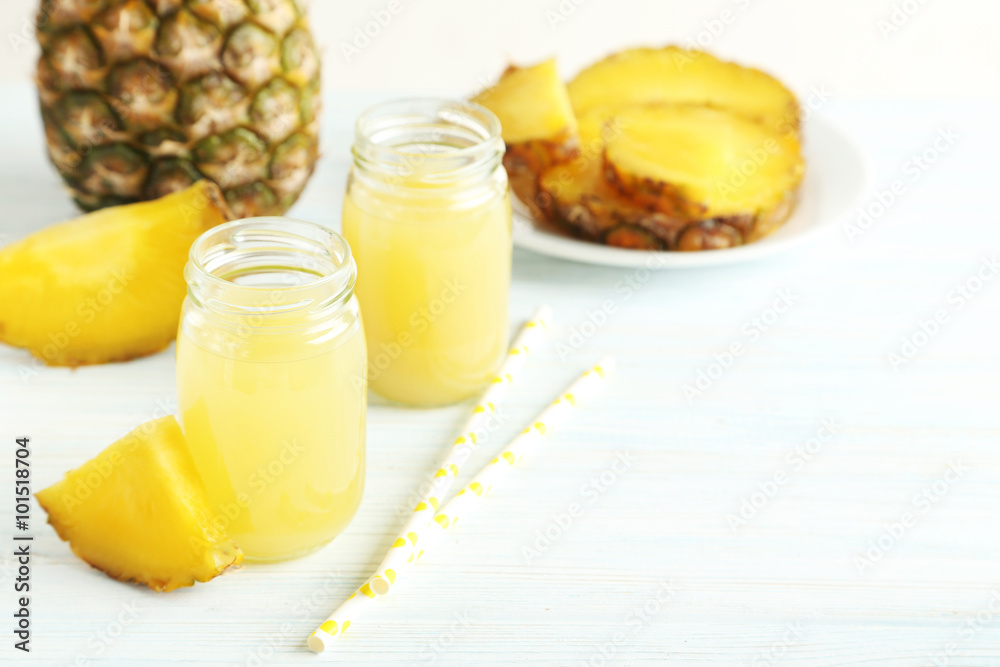 Bottles of pineapple juice on a white wooden table