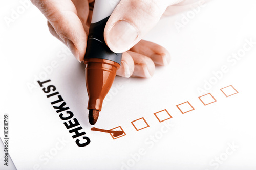 Checklist on white with marker and woman hand