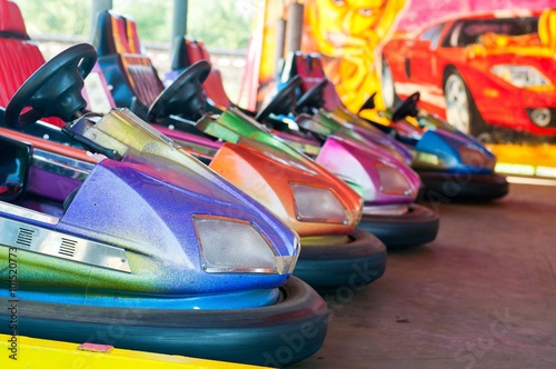Colorful electric bumper car in autodrom in the fairground attractions at amusement park. Selective focus on the cars