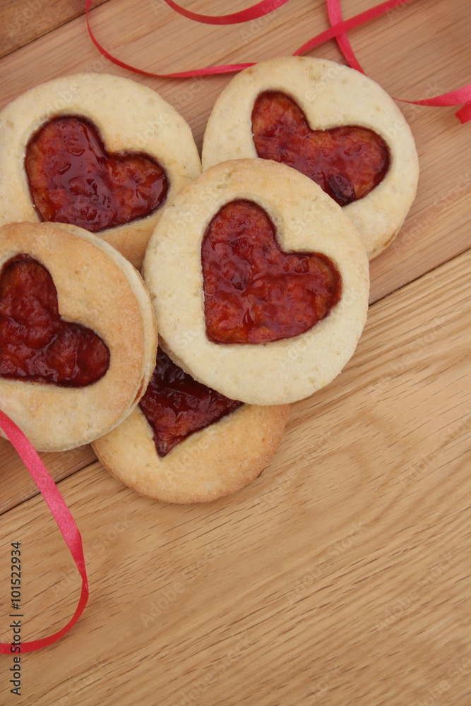 biscotti a forma di cuore con marmellata su tavolo di legno. San Valentino biscotti a forma di cuore con marmellata su tavolo di legno. San Valentino