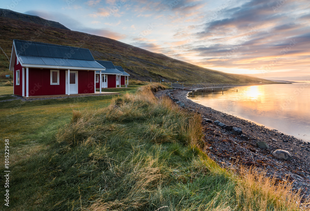 Samolepka Red cottage seaside with plant foreground and mountain range background during s