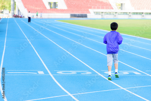 Boy runnin on blue track