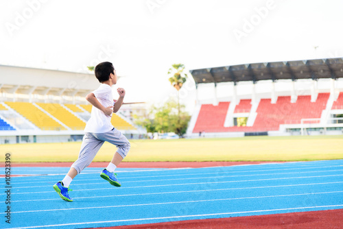 Boy runnin on blue track
