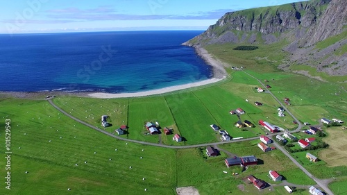 Scenic village Unstad on Lofoten islands in Norway with green farmlands and beautiful sandy beach on the coast. Aerial 4k Ultra HD.
