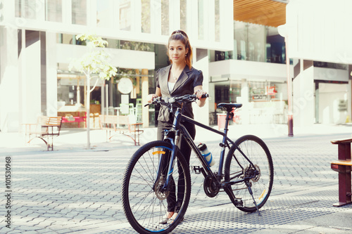 Fototapeta Naklejka Na Ścianę i Meble -  Young woman commuting on bicycle