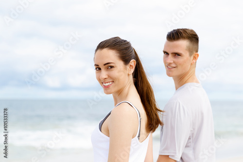 Young couple looking thoughtful while standing next to each other on beach © Sergey Nivens