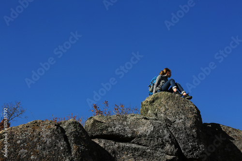Woman sitting on the top of the mountain