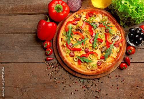 Delicious pizza with vegetables on wooden background