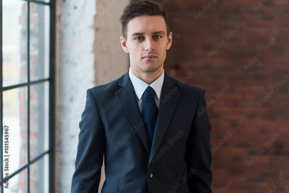 Portrait of a confident young businessman standing in office. Portrait of a confident young businessman standing in office.