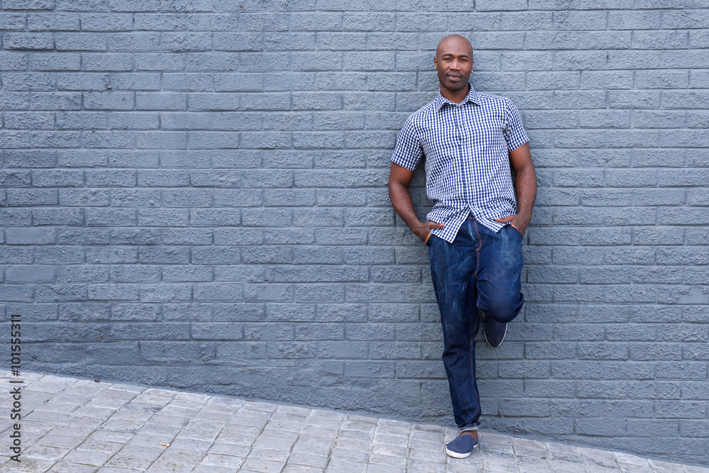 Relaxed african american man leaning against wall