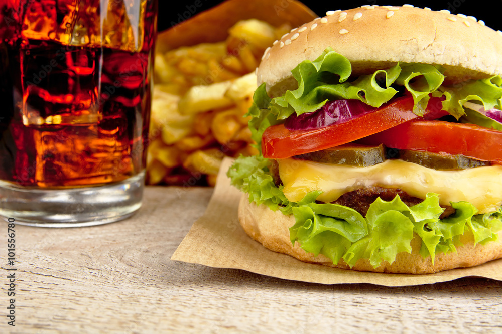 Φωτογραφία Cheeseburger,glass of cola and french fries on wooden