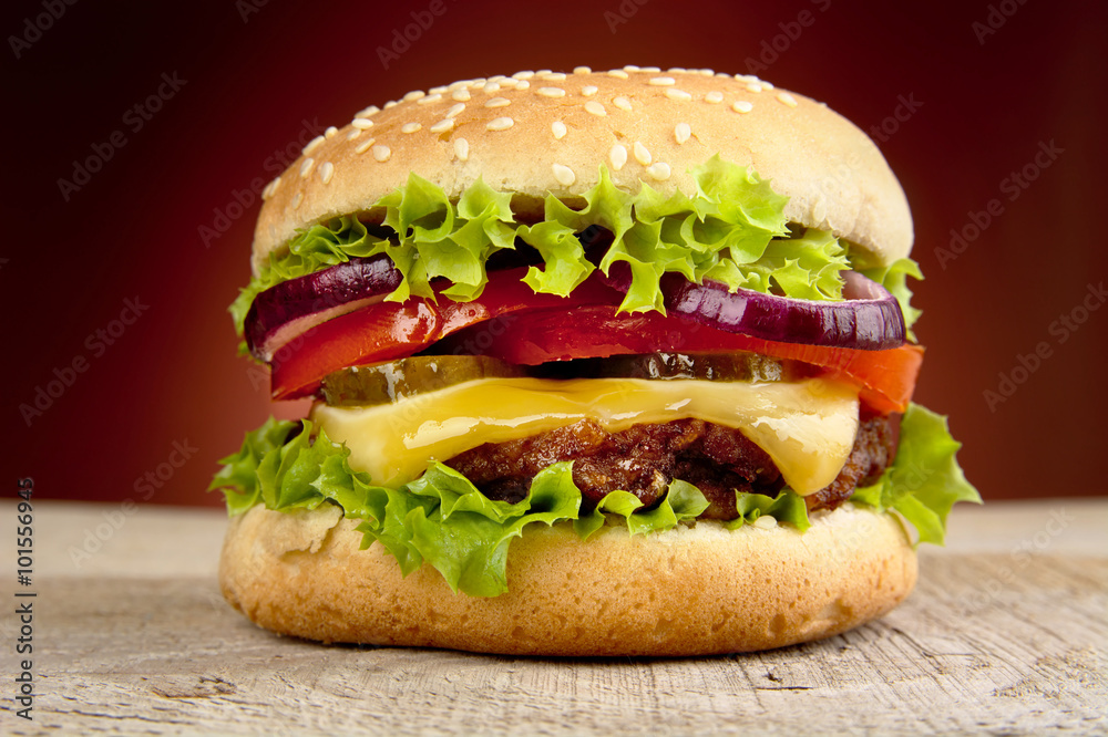 Big cheeseburger isolated on red background - obrazy, fototapety, plakaty 