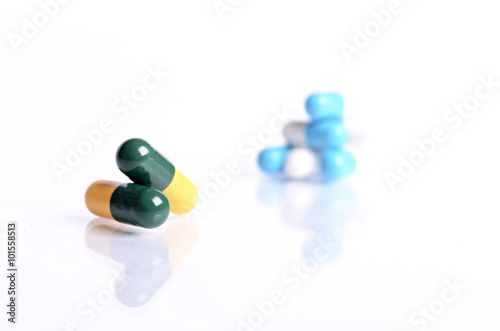 Tablets isolated on a white background. Reflection of pills on a glass. Medicine´s background. Pharmacy. Close up of capsules.