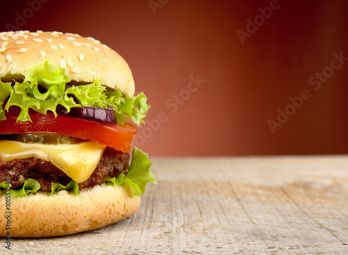 Big cheeseburger cropped on red background photo