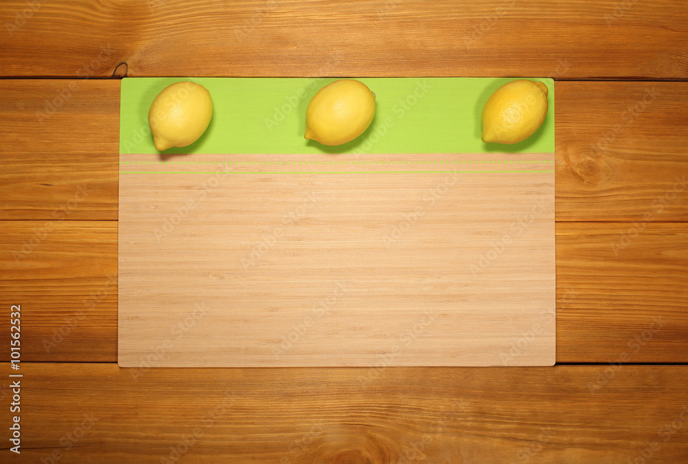 Banner for design menu of cafe or recipe cooking: three lemon lie on a bamboo panel on rustic vintage table from brown textured boards. Banner for design menu of cafe or recipe cooking: three lemon lie on a bamboo panel on rustic vintage table from brown textured boards.