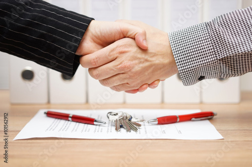 client and agent are handshaking over real estate contract and k