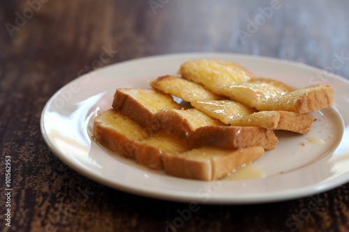 Buttered toast with sweetened condensed milk sliced on white dish