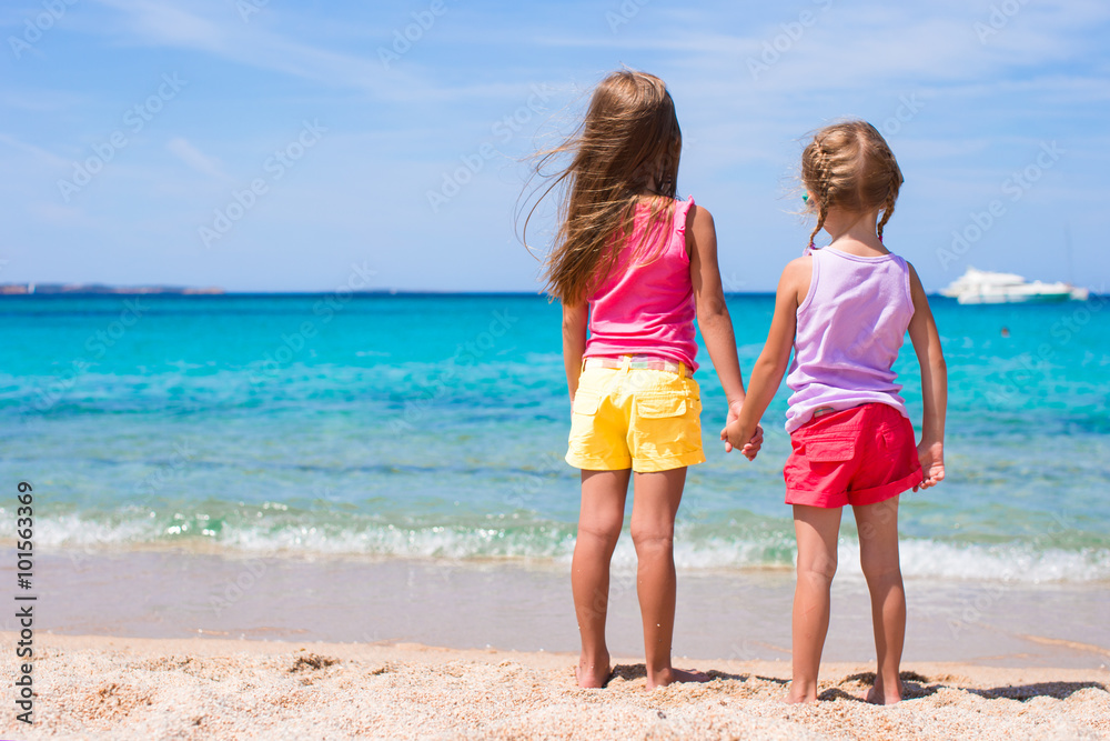Adorable little girls at tropical beach during summer vacation