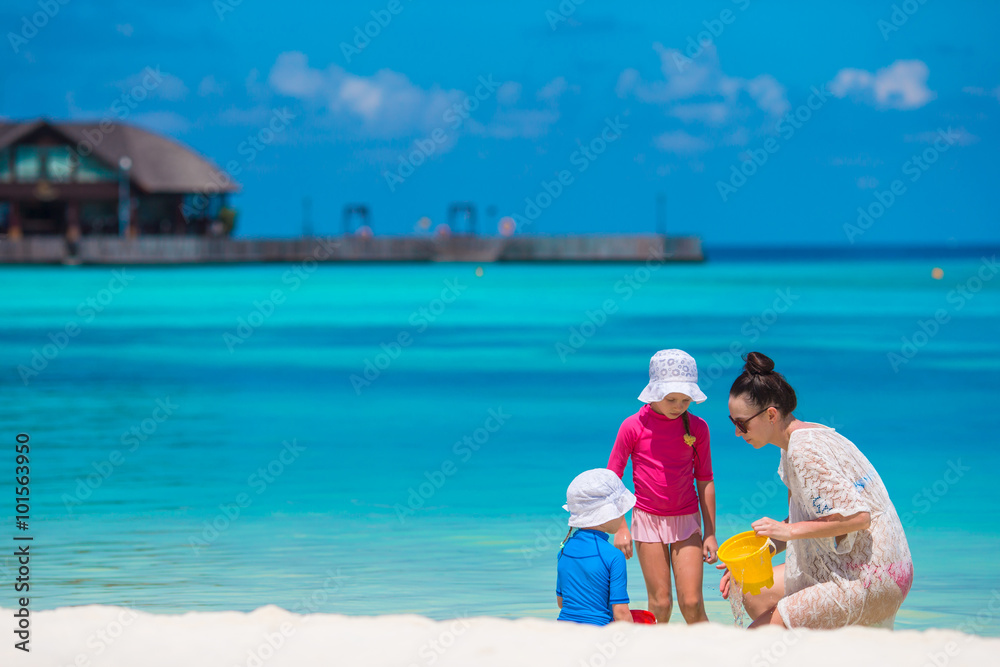 Happy family playing with beach toys on tropical vacation