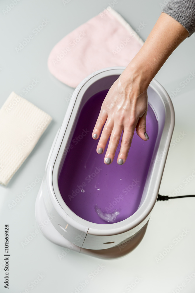 Fototapeta premium Female hands in a paraffin wax bowl