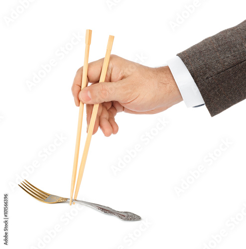 Hand with chopsticks and fork photo