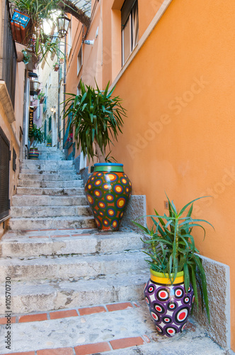 A characteristic narrow alley of Taormina, Eastsicily, with some typical colored ceramic vases