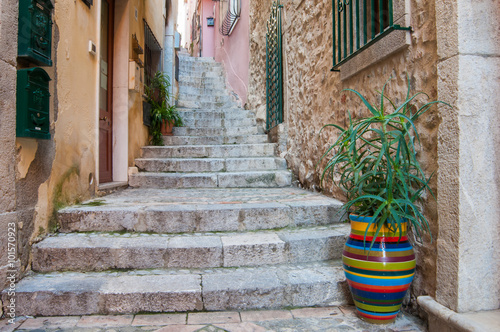 Fototapeta Naklejka Na Ścianę i Meble -  A characteristic narrow alley of Taormina, Eastsicily, with some typical colored ceramic vases