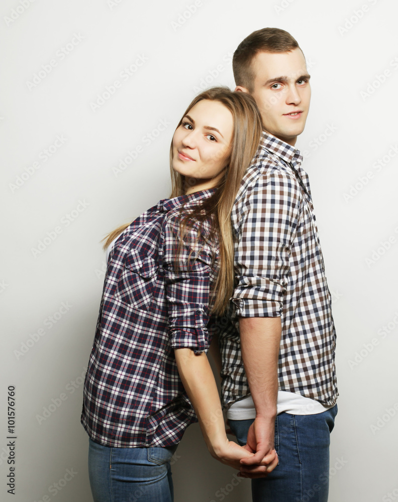 lovely happy couple hugging over grey background. lovely happy couple hugging over grey background.