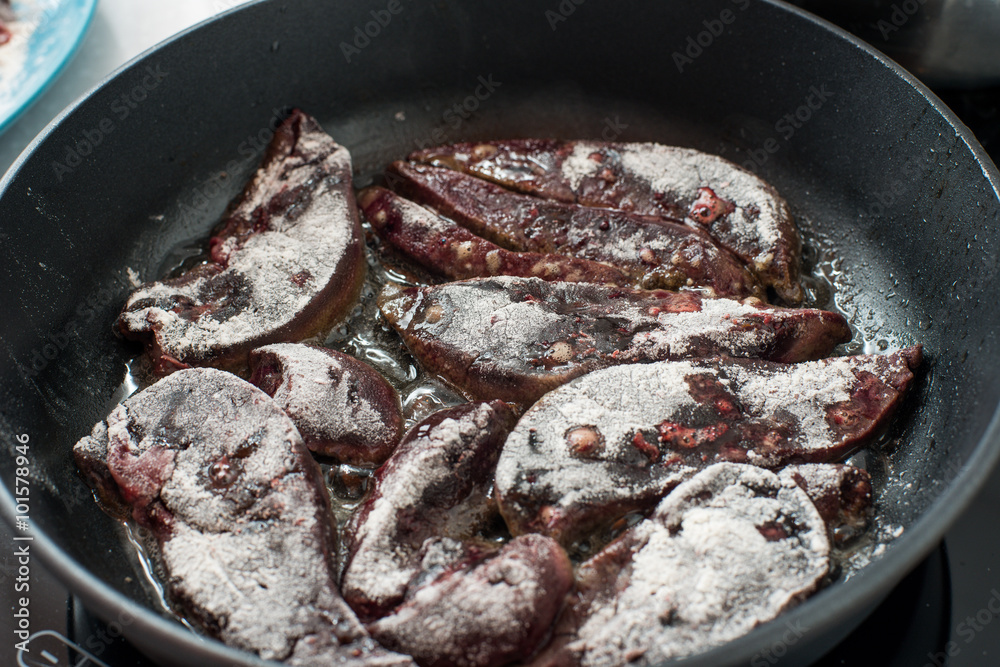 Cooking beef liver covered in flour on a frying pan. Cooking beef liver covered in flour on a frying pan.