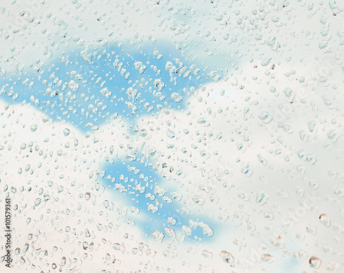 Water drop on car glass with sky background.