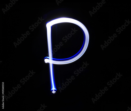 P Papa alphabet hand writing blue light  over black background. photo