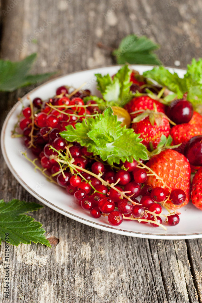assorted garden berries on a plate on wooden background assorted garden berries on a plate on wooden background