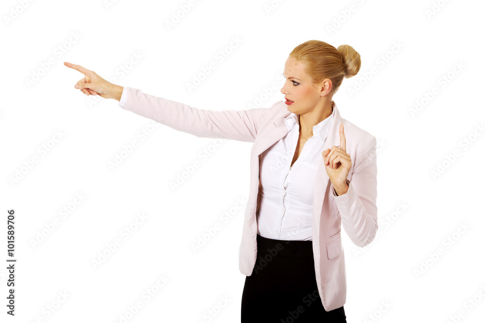 Young focus business woman explaining something and pointing at board or copyspace Young focus business woman explaining something and pointing at board or copyspace