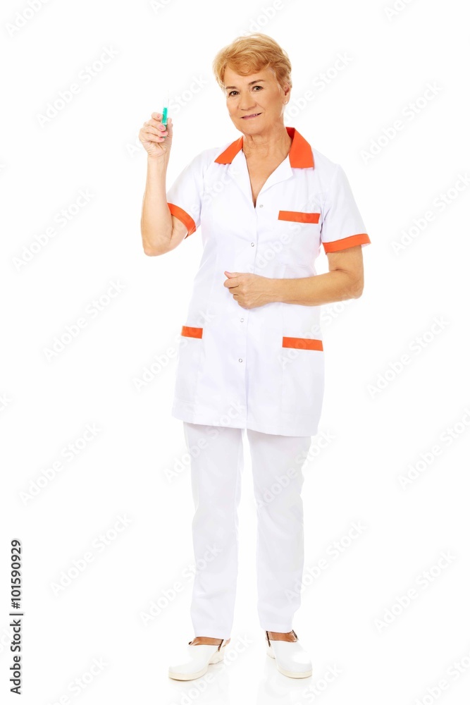 Smile elderly female doctor or nurse holds syringe Smile elderly female doctor or nurse holds syringe